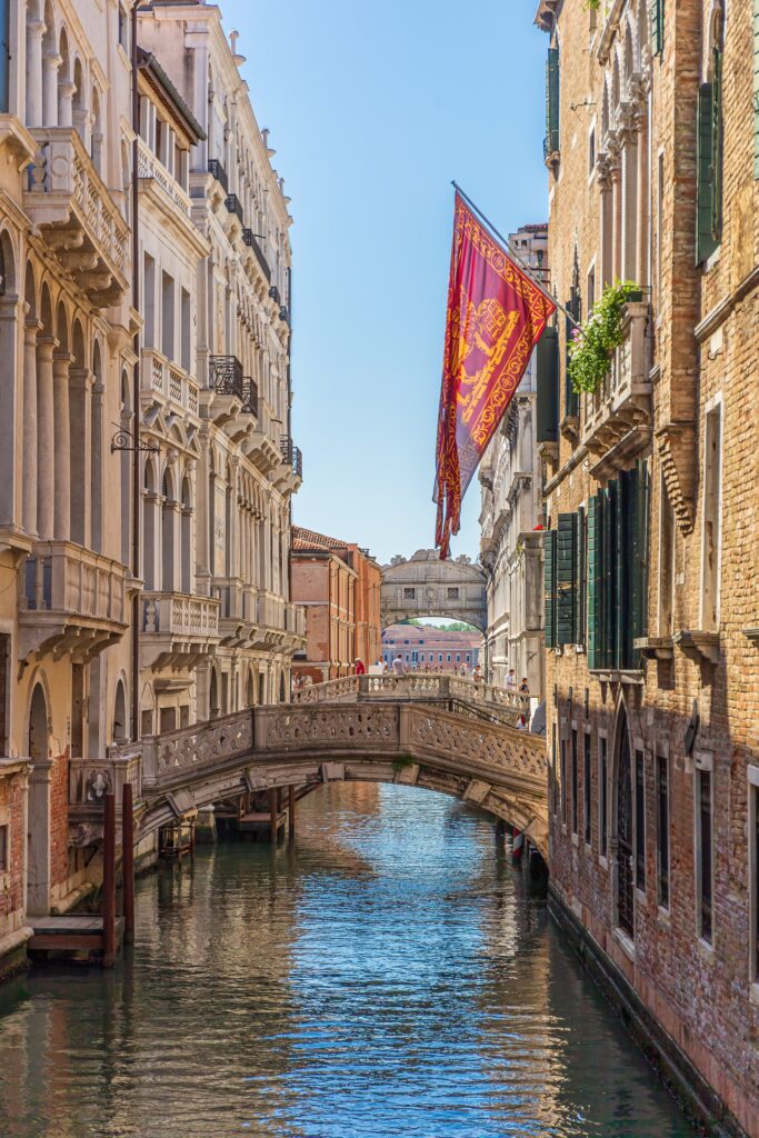 A vertical shot of a canal with bridge in Venice, Italy